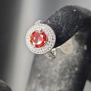 E-8 silvertone ring with red center stones and clear accents